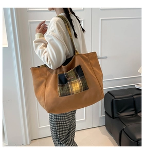 Detail of a large brown canvas tote bag with a vintage yellow plaid pocket and handles