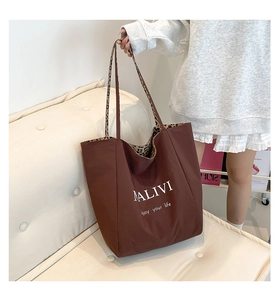 Detail of coffee brown tote bag with leopard print lining and white logo print