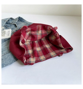 Detail of burgundy canvas tote bag showing classic red and beige plaid lining texture