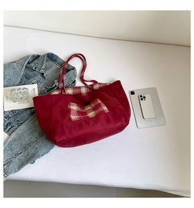Detail of red tote bag with red and white checkered pocket and spacious interior