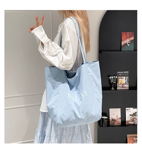 Close-up of light blue tote bag featuring MLIVI print and leopard print lining detail