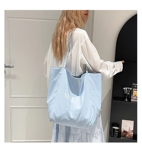 Detail of light blue tote bag featuring MALIVI logo and Enjoy your life text print