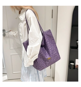 Detailed close-up of large purple leopard print tote bag with metallic logo and wide straps