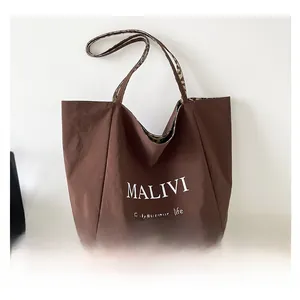Close-up of brown tote bag featuring MALIVI print and leopard pattern trim details