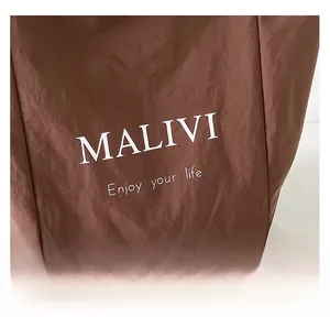 Close-up of chocolate brown waterproof nylon fabric texture with white MALIVI lettering