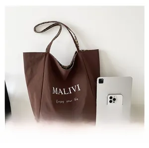 Large capacity dark brown tote bag showing interior space with laptop and tablet