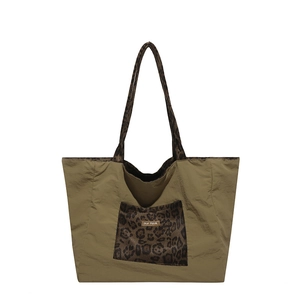 Detail of olive green canvas tote bag featuring leopard print pocket and strap design