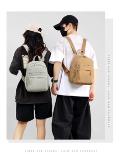 Rear view of couple wearing minimalist light gray and khaki backpacks with clean aesthetic