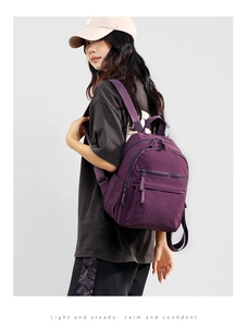 Detail view of purple lightweight nylon backpack showing side pocket and durable wide straps