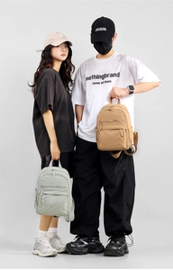 Detail of dual minimalist waterproof nylon backpacks with multiple zipper pockets