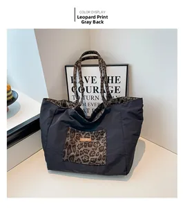 Detail of a black large-capacity canvas tote bag with leopard print pocket and lining