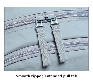 Macro detail of smooth SBS zippers with extended pullers on a light blue backpack