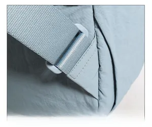 Reinforced stitching detail on the light blue nylon shoulder strap of the backpack