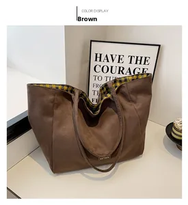 Detail view of coffee-colored canvas tote featuring yellow checkered lining and tag