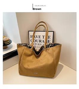 Detailed close-up of brown suede tote bag with black and white gingham lining and logo