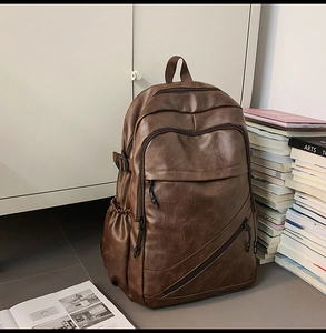 Detail of a brown leather backpack with multiple compartments and a retro texture finish