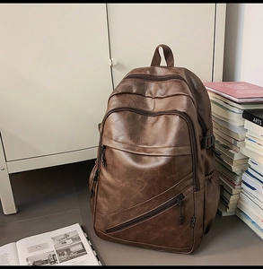 Close-up of a vintage dark brown leather backpack with multiple zippers in a lifestyle setting