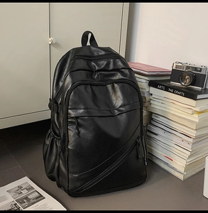 Close-up of matte black synthetic leather texture and side zipper on a laptop backpack