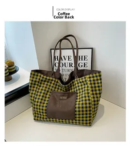 Close-up of yellow and black checkered canvas tote bag with brown suede front pocket