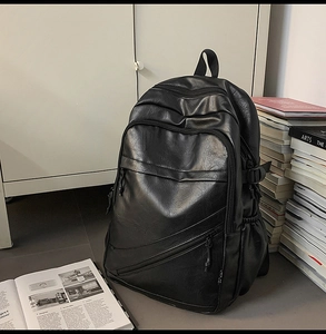 Detail of minimalist black PU leather business backpack in a modern office interior setting