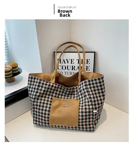 Detail of blue plaid canvas tote bag with brown suede pocket and our fave label
