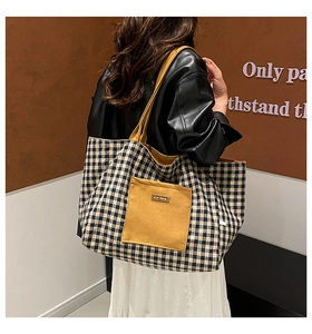 Close-up of checkerboard canvas tote with yellow suede pocket and our fave leather label
