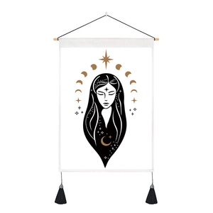 Detail of wall tapestry featuring gold moon, stars, and female portrait with black tassels