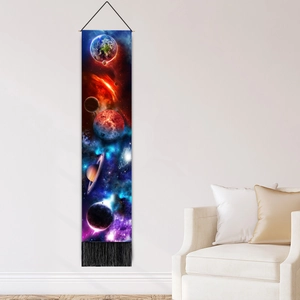 Vertical galaxy tapestry with planets and black tassels hanging above a white sofa