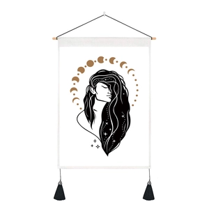 Detail view of gold moon phases and stars art on a bohemian wall tapestry with tassels