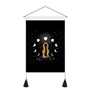 Detail of bohemian wall tapestry with meditating girl, moon phases, and black tassels