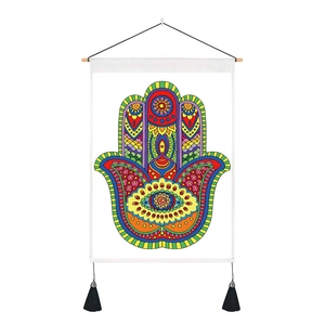 Close-up of Hamsa Hand tapestry with wooden pole, tassels and boho geometric pattern