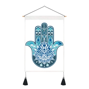 Close-up of bohemian Hamsa Hand tapestry with blue lotus pattern and black tassels