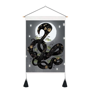 Close-up of floral snake and moon tapestry with wood rod and black decorative tassels