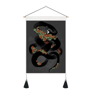 Detail of floral moon phase snake tapestry featuring wood hanger and black tassels