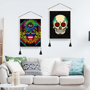 Bohemian skull wall tapestry with tassels and wooden hanging poles in a home interior setting