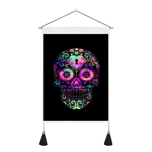 Detail of bohemian skull tapestry with floral patterns, wooden rod, and black tassels