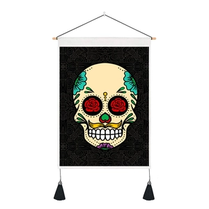 Detailed view of Mexican sugar skull tapestry with red rose eyes and black fringe tassels