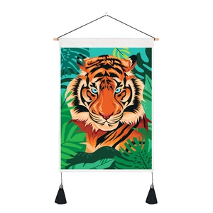 Detail of tiger wall hanging featuring tropical leaves, wooden rod and black tassels
