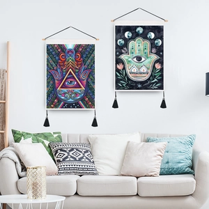 Tapestries murales bohèmes Main de Fatma et Œil avec perches en bois et glands dans un salon