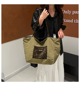 Close-up of olive green tote bag with leopard print pocket and shoulder strap detail