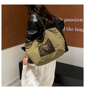 Close-up of olive green canvas tote bag with leopard print pocket on female model