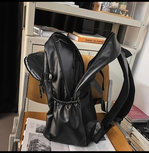 Detailed view of the large capacity black PU leather backpack with sturdy metal side buckles