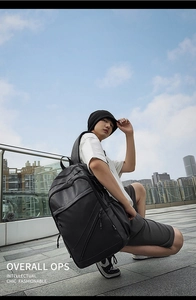 Men's black synthetic leather backpack featured in a stylish urban city setting