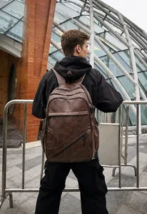 Brown vintage leather backpack for men shown on model for size and scale reference