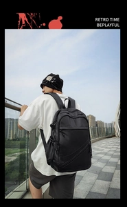 Outdoor shot of a black leather business backpack for men showing back fit on a model