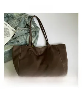 Detail of dark brown faux suede tote bag with our fave label and retro style