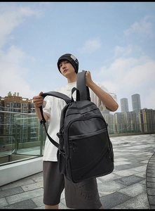 Detail of waterproof black faux leather laptop backpack with multiple zipper compartments