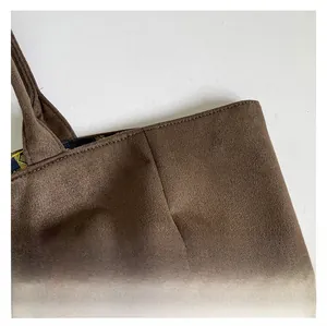 Detail of high-quality brown suede tote bag featuring durable stitching and patterned lining