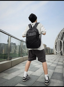 Detailed view of black leather business backpack with wide straps on male model back