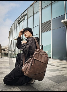 Outdoor urban shot of a vintage brown leather backpack with multi-zipper compartments